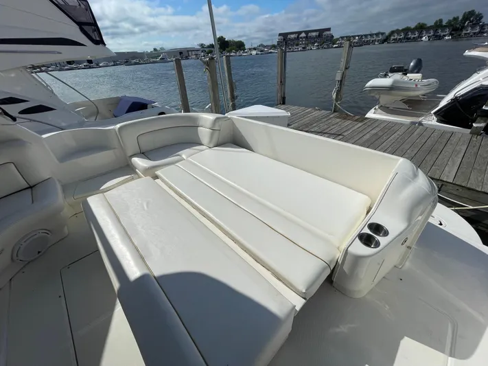 Limin Yacht Photos Pics 2000 Sea Ray 460 Sundancer yacht with white seating, docked by a scenic waterfront.