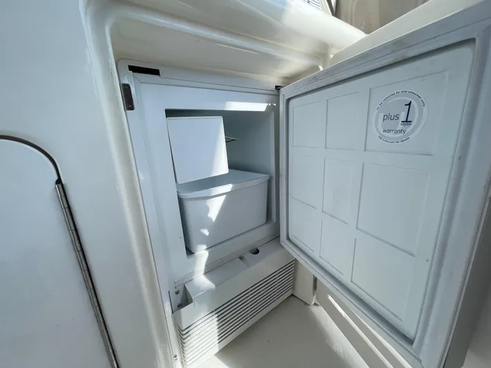 Limin Yacht Photos Pics Open refrigerator on a 2000 Sea Ray 460 Sundancer yacht, showing interior storage space.