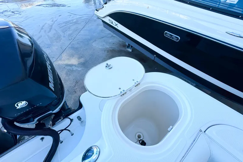 Turn Key Yacht Photos Pics 2006 Boston Whaler 285 Conquest boat with open storage compartment and Mercury engine.