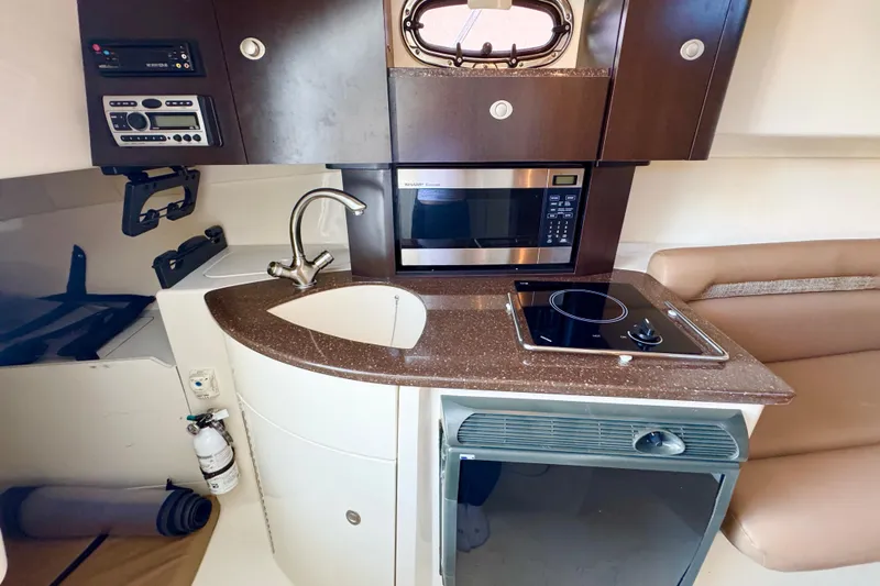 Turn Key Yacht Photos Pics 2006 Boston Whaler 285 Conquest boat interior with kitchenette, sink, microwave, and stove.
