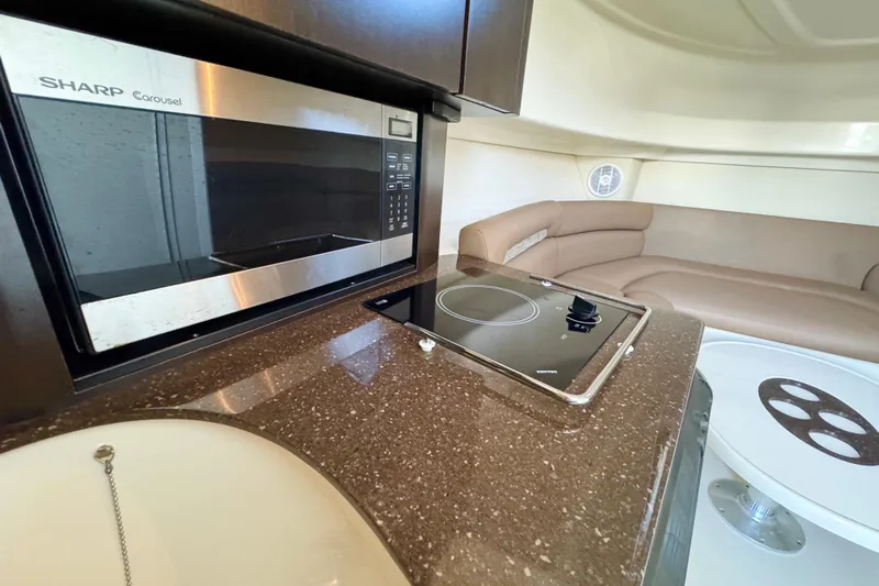 Turn Key Yacht Photos Pics Interior of 2006 Boston Whaler 285 Conquest with microwave, cooktop, and seating area.