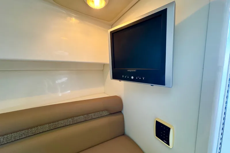 Turn Key Yacht Photos Pics Interior of 2006 Boston Whaler 285 Conquest with wall-mounted TV and cushioned seating.