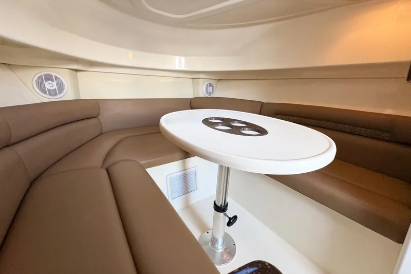 Turn Key Yacht Photos Pics 2006 Boston Whaler 285 Conquest cabin interior with brown seating and white table.