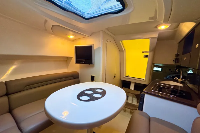 Turn Key Yacht Photos Pics Interior of 2006 Boston Whaler 285 Conquest with seating, table, and kitchenette.