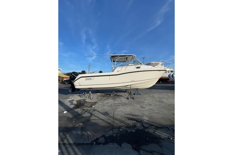 Turn Key Yacht Photos Pics 2006 Boston Whaler 285 Conquest boat on stands under clear blue sky.