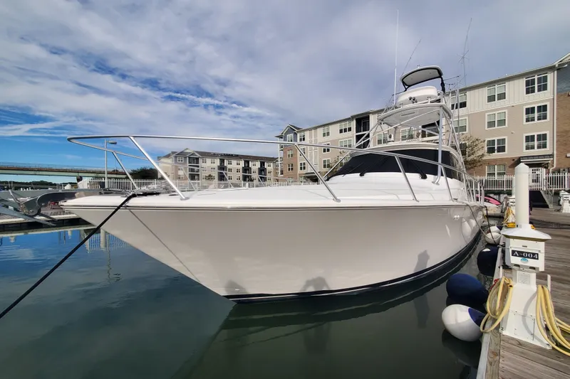 Salty Soul Yacht Photos Pics 2023 Viking 48 Sport Tower yacht docked at marina, under a clear blue sky.