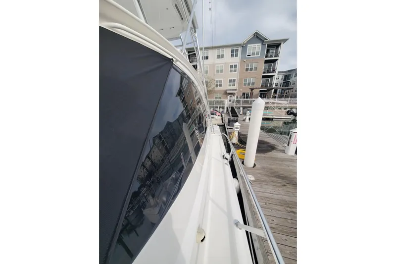 Salty Soul Yacht Photos Pics 2023 Viking 48 Sport Tower yacht docked at marina with modern buildings.