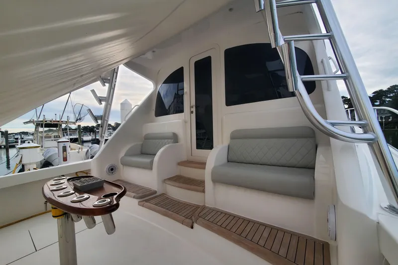 Salty Soul Yacht Photos Pics 2023 Viking 48 Sport Tower yacht interior with seating and ladder, docked at marina.