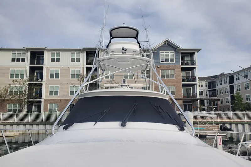 Salty Soul Yacht Photos Pics 2023 Viking 48 Sport Tower yacht docked near modern apartments.