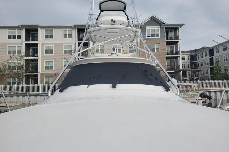 Salty Soul Yacht Photos Pics 2023 Viking 48 Sport Tower yacht docked near modern apartments.