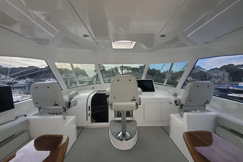 Salty Soul Yacht Photos Pics Interior of 2023 Viking 48 Sport Tower yacht with three helm seats and panoramic windows.