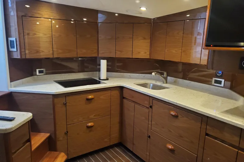 Salty Soul Yacht Photos Pics Luxurious kitchen interior of 2023 Viking 48 Sport Tower yacht with modern wood cabinetry.