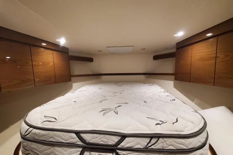 Salty Soul Yacht Photos Pics 2023 Viking 48 Sport Tower cabin with bed and wooden cabinets.