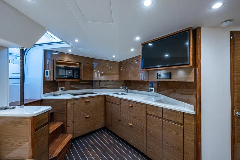Salty Soul Yacht Photos Pics Luxurious interior of 2023 Viking 48 Sport Tower yacht with modern kitchen and sleek design.