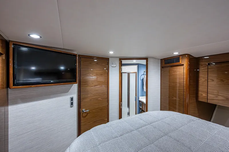 Salty Soul Yacht Photos Pics Luxurious interior of 2023 Viking 48 Sport Tower yacht cabin with TV and wood finishes.