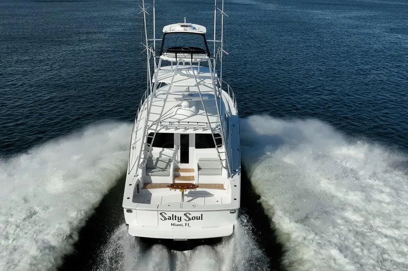 Salty Soul Yacht Photos Pics 2023 Viking 48 Sport Tower yacht cruising on open water, rear view.