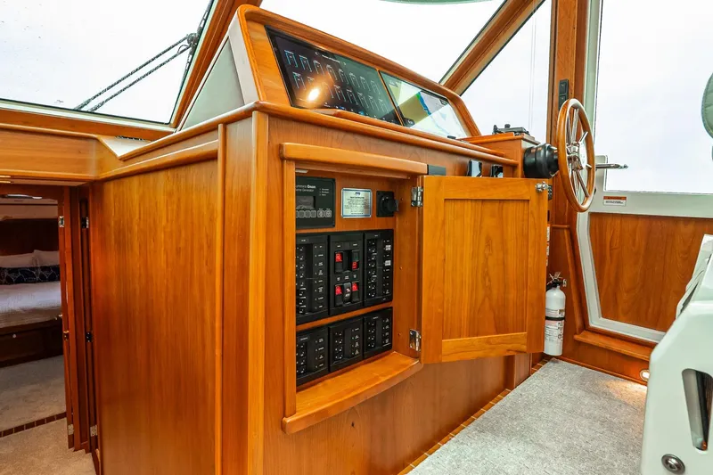  Yacht Photos Pics 2024 Sabre 58 Salon Express interior with wooden cabinetry and control panel.