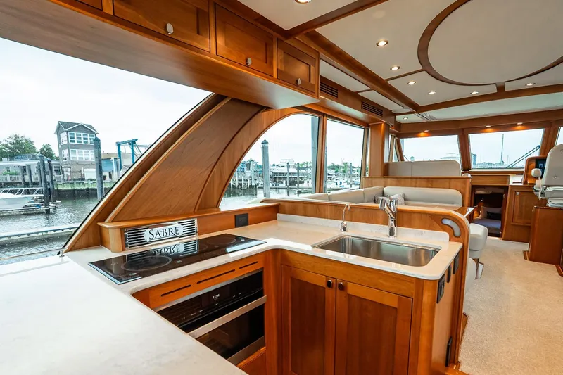  Yacht Photos Pics Luxurious interior of 2024 Sabre 58 Salon Express yacht with modern kitchen and scenic windows.