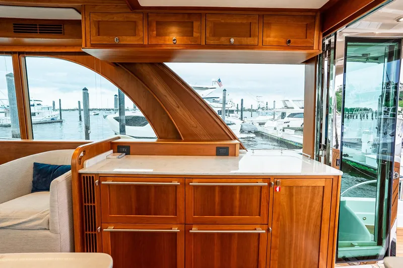  Yacht Photos Pics Luxurious interior of 2024 Sabre 58 Salon Express yacht with wooden cabinetry and marina view.