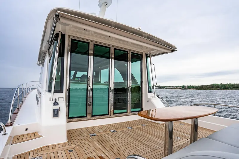  Yacht Photos Pics 2024 Sabre 58 Salon Express yacht with teak deck and glass doors on open water.