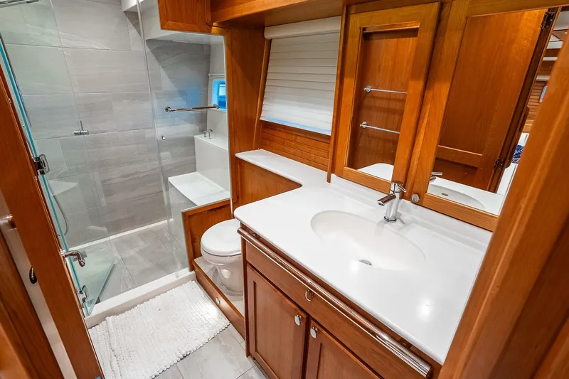  Yacht Photos Pics Luxurious bathroom in 2024 Sabre 58 Salon Express yacht with wood cabinetry and modern fixtures.