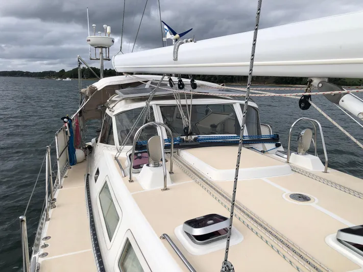 Ibis Yacht Photos Pics Outbound 46 sailboat from 2008 on calm waters under cloudy skies.