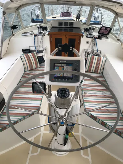 Ibis Yacht Photos Pics Cockpit of 2008 Outbound 46 sailboat with striped seating and navigation equipment.