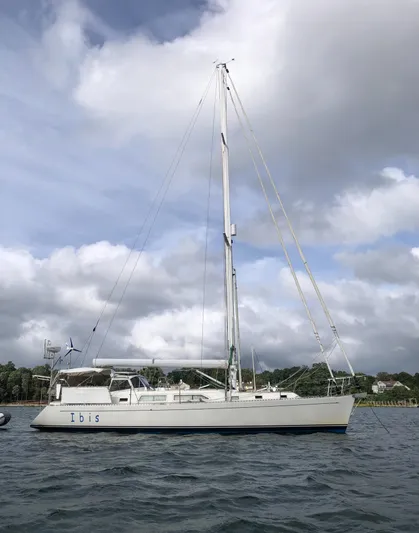 Ibis Yacht Photos Pics Outbound 46 sailboat from 2008 on calm waters under a cloudy sky.