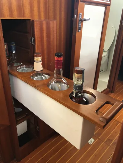 Ibis Yacht Photos Pics Built-in liquor cabinet on 2008 Outbound 46 yacht with wooden finish and bottle storage.