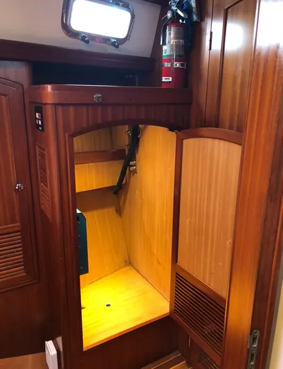 Ibis Yacht Photos Pics Wooden interior of a 2008 Outbound 46 sailboat with storage space and fire extinguisher.