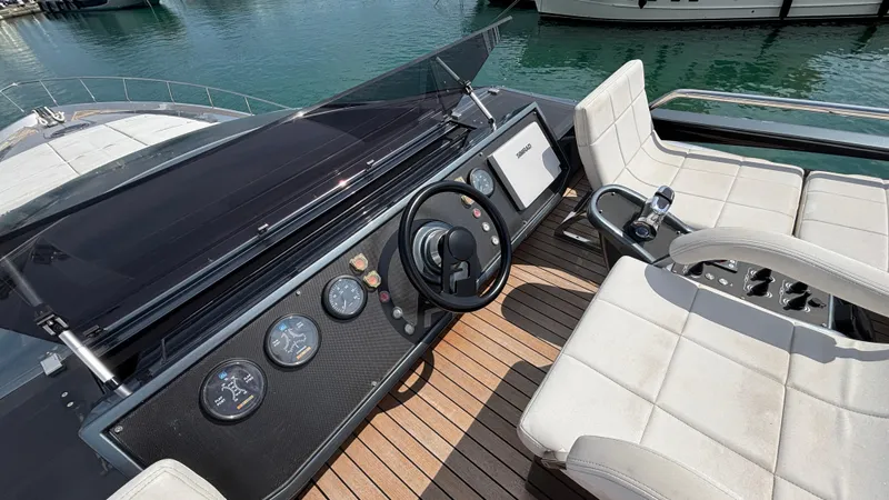 Dolce Vita Yacht Photos Pics Helm of 2011 Pershing 74 yacht with steering wheel and gauges, docked on calm water.