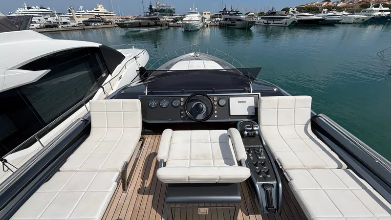 Dolce Vita Yacht Photos Pics Luxury 2011 Pershing 74 yacht helm with white seating, docked in a marina.