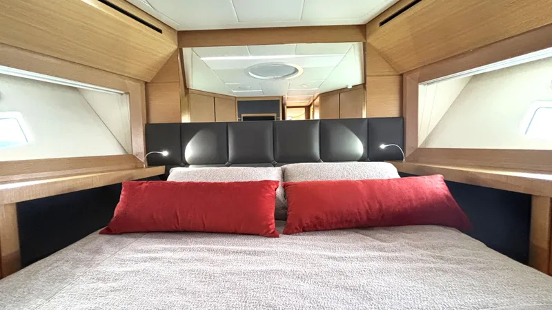 Dolce Vita Yacht Photos Pics Luxurious bedroom interior of 2011 Pershing 74 yacht with red pillows and modern design.