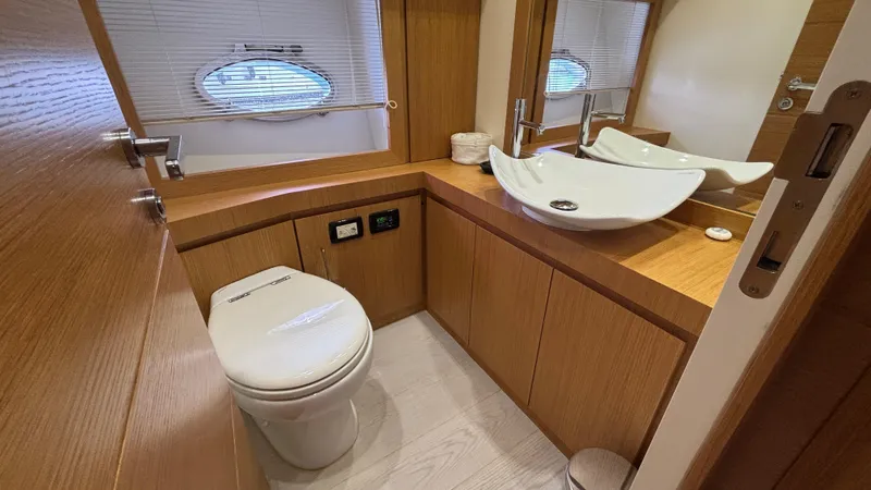 Dolce Vita Yacht Photos Pics Luxurious bathroom in 2011 Pershing 74 yacht with modern fixtures and wooden cabinetry.
