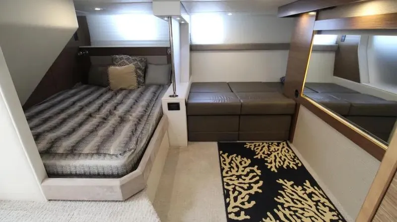 Stella Maris Yacht Photos Pics Luxurious 2016 Cruisers Yachts 45 Cantius cabin with bed, seating, and decorative rug.