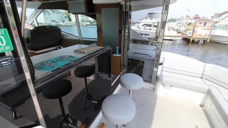 Stella Maris Yacht Photos Pics Interior of 2016 Cruisers Yachts 45 Cantius with bar stools and waterfront view.
