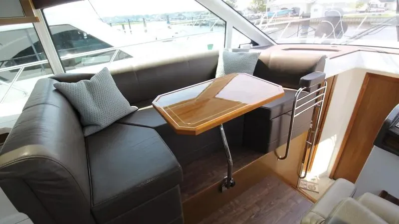 Stella Maris Yacht Photos Pics Interior of 2016 Cruisers Yachts 45 Cantius with leather seating and wooden table.