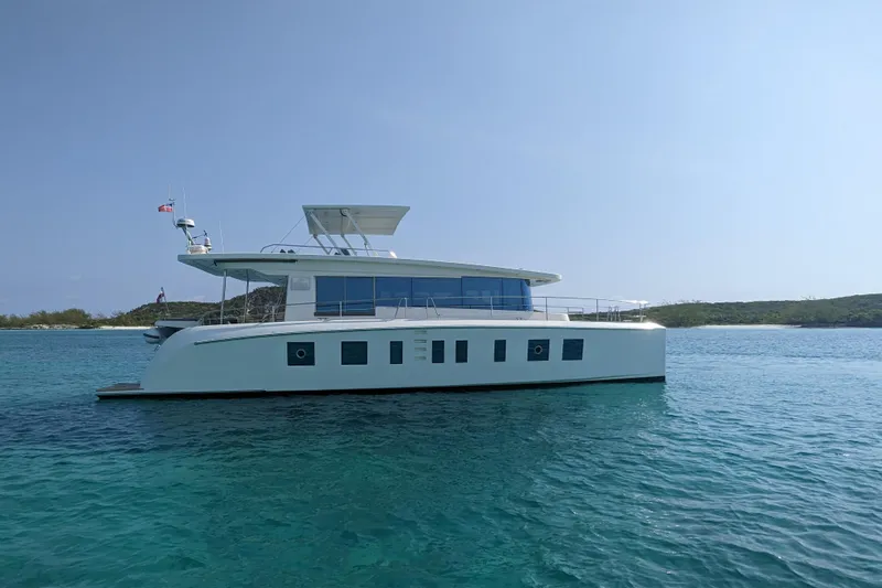 Silent Seven Yacht Photos Pics Silent 55 yacht from 2020 on clear blue water, with scenic island backdrop.