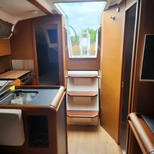 Skye Yacht Photos Pics Interior of 2023 Jeanneau Sun Odyssey 349 yacht, featuring modern kitchen and wooden cabinetry.