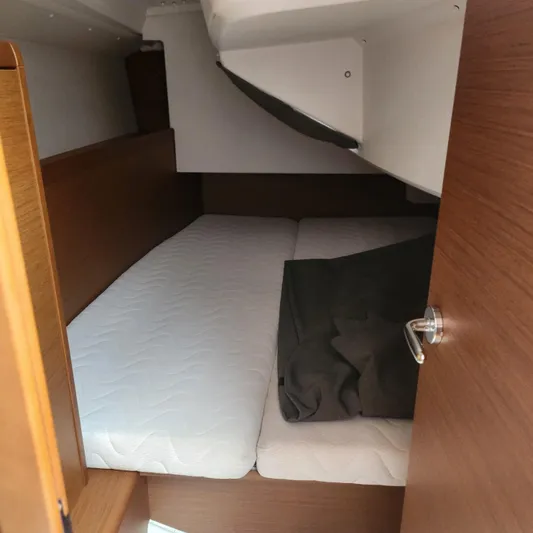 Skye Yacht Photos Pics 2023 Jeanneau Sun Odyssey 349 cabin interior with wooden finish and cozy bedding.