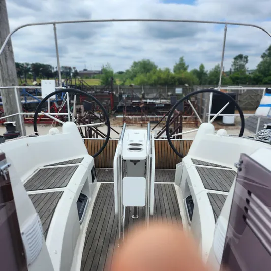 Skye Yacht Photos Pics 2023 Jeanneau Sun Odyssey 349 cockpit with dual steering wheels, docked outdoors.