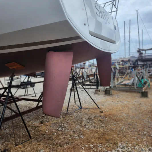 Skye Yacht Photos Pics 2023 Jeanneau Sun Odyssey 349 sailboat on dry dock, showcasing dual rudders.