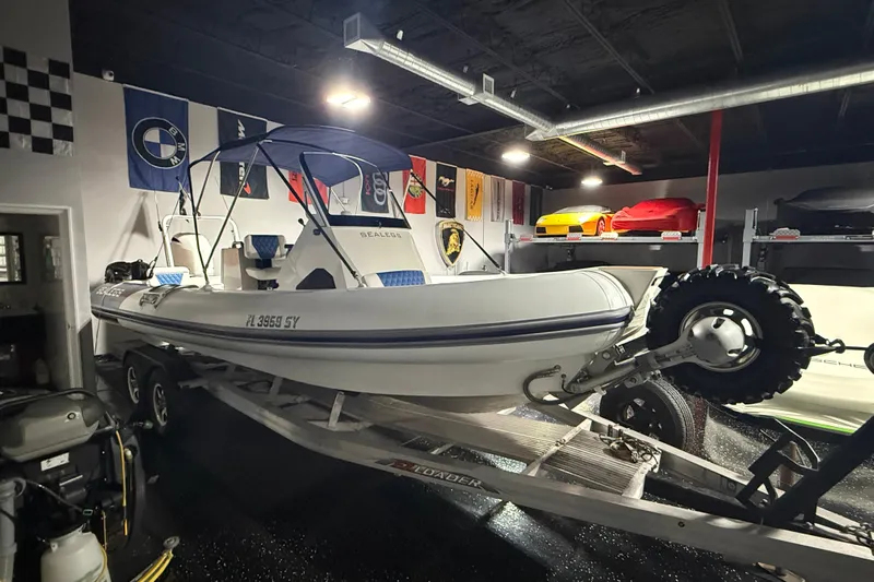 7.5m Hydrasol Rib Yacht Photos Pics 2021 Sealegs 7.5M RIB boat on trailer in a garage with flags and cars.