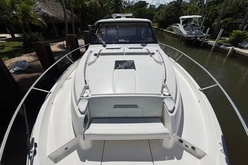  Yacht Photos Pics 2024 Pursuit OS 445 Offshore boat docked in a scenic canal setting.