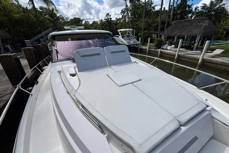  Yacht Photos Pics 2024 Pursuit OS 445 Offshore yacht with sun deck, docked near tropical surroundings.