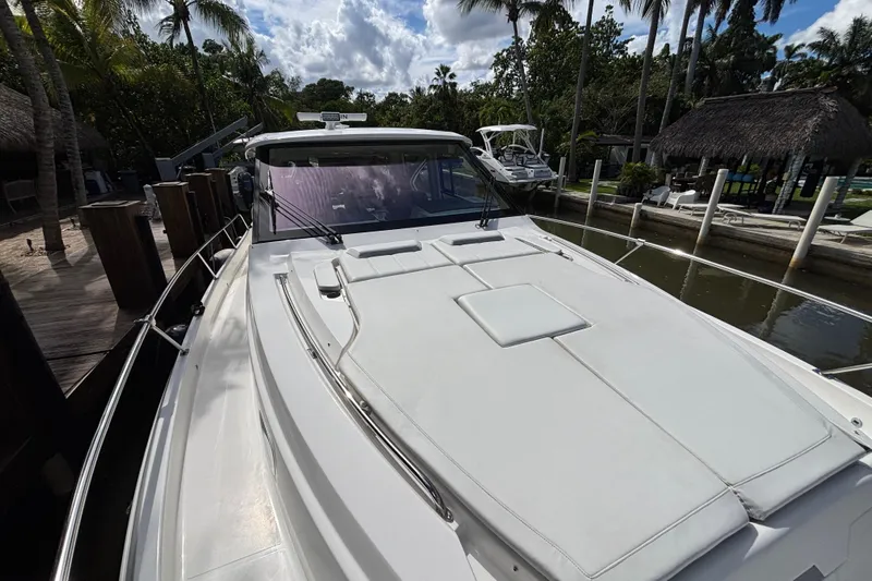  Yacht Photos Pics 2024 Pursuit OS 445 Offshore boat docked, showcasing sleek design and spacious deck.