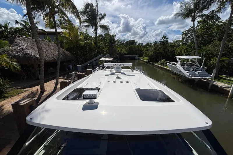  Yacht Photos Pics 2024 Pursuit OS 445 Offshore yacht docked in tropical canal setting.