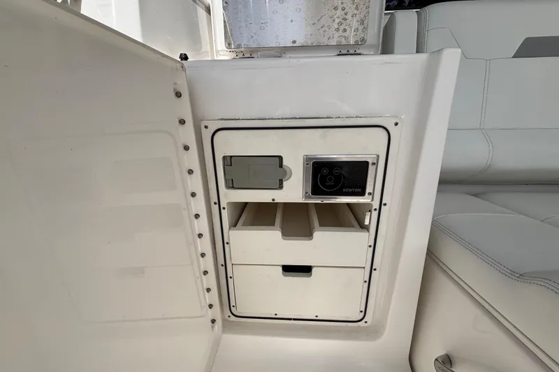 Yacht Photos Pics 2024 Pursuit OS 445 Offshore interior storage compartment with Kenyon control panel.