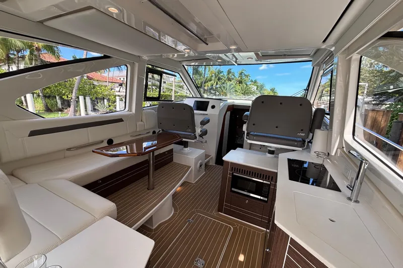  Yacht Photos Pics Luxurious interior of 2024 Pursuit OS 445 Offshore yacht with modern seating and kitchen amenities.