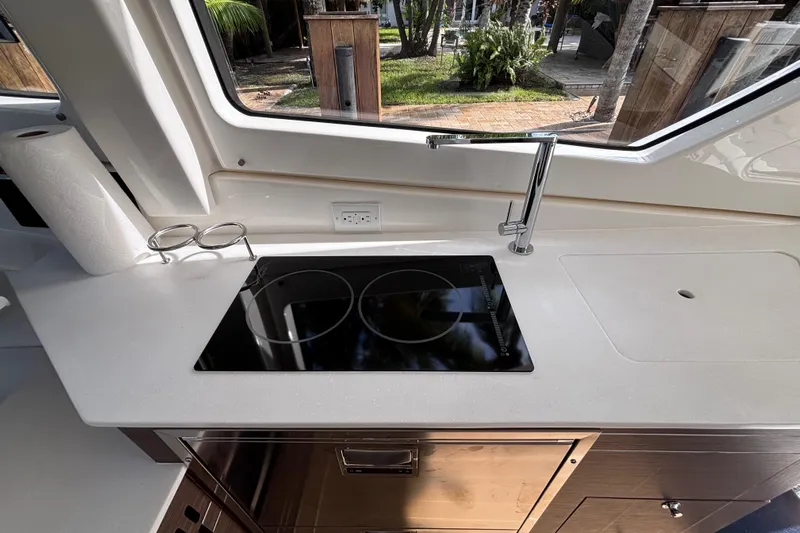  Yacht Photos Pics 2024 Pursuit OS 445 Offshore yacht kitchen with sleek stovetop and modern faucet.